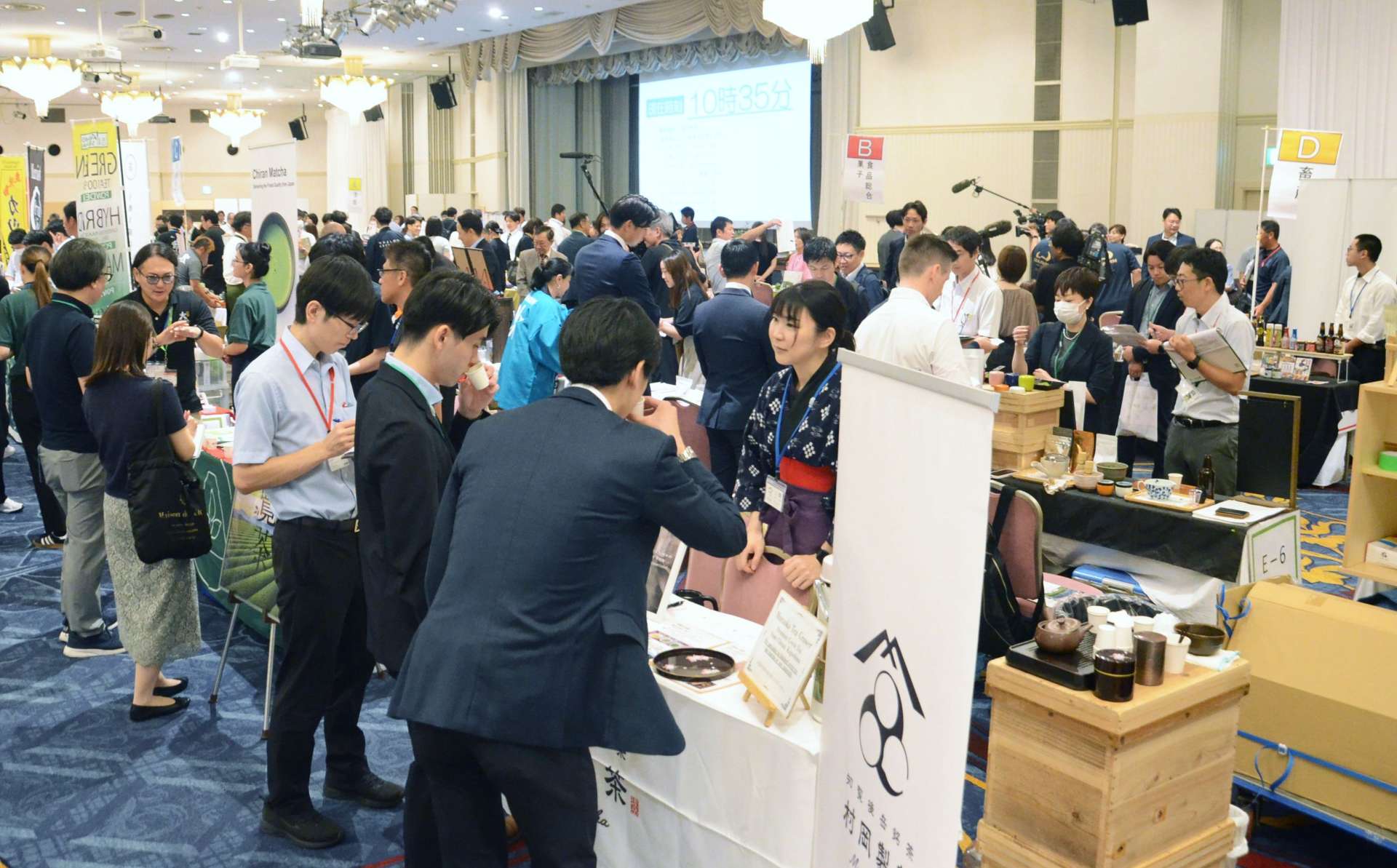 県産品の輸出拡大に向け、ブースで商談するバイヤーと出展者＝１４日、鹿児島市