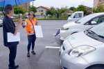 〈資料写真〉日本カーシェアリング協会職員（奥）から説明を受ける利用者＝８月２０日、霧島市国分中央３丁目の市お祭り広場駐車場