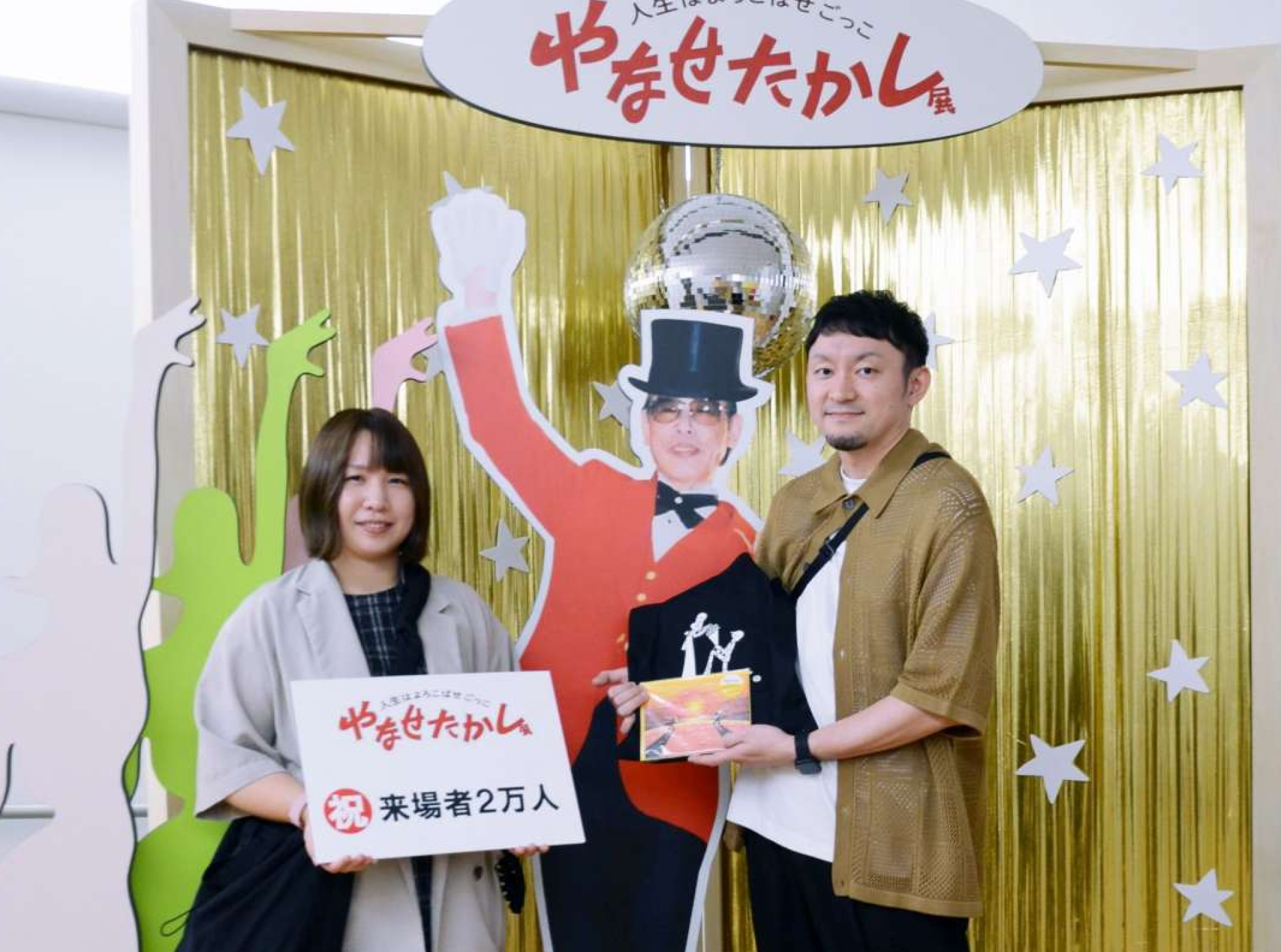 「やなせたかし展」の２万人目の入場者となった平澤恒さん（右）、宏美さん夫妻＝１６日、鹿児島市のかごしま近代文学館