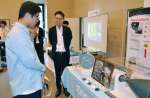宇宙関連企業のブースを見学する参加者＝１６日、鹿児島市のカクイックス交流センター