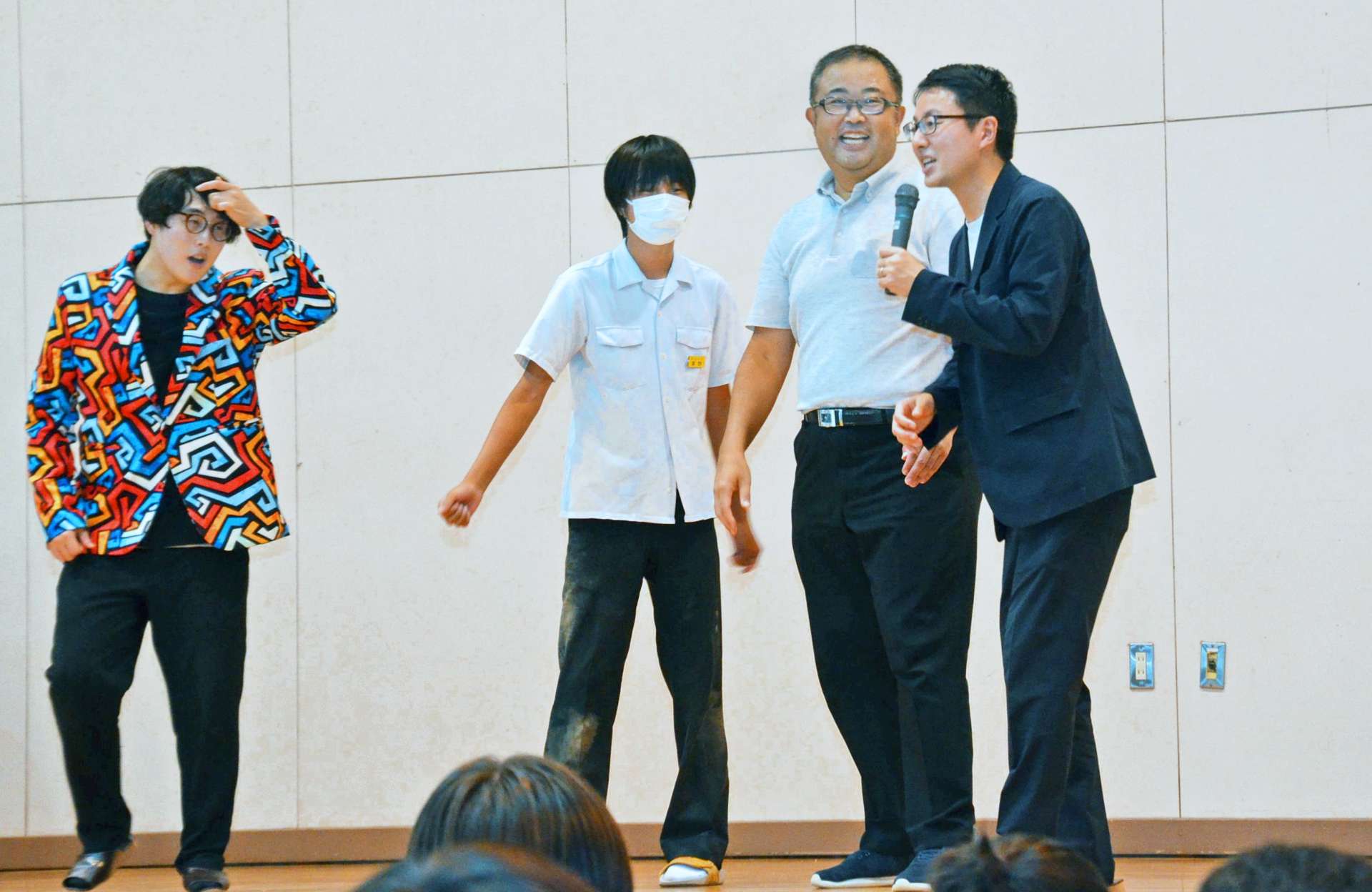 教諭や生徒と一緒に、相手を受け入れるコミュニケーションを実演するオシエルズの矢島ノブ雄さん（左端）と野村真之介さん（右端）＝鹿児島市の谷山北中学校