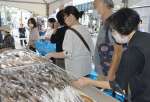 原木シイタケや加工品を品定めする買い物客＝１６日、鹿児島市のよかど鹿児島