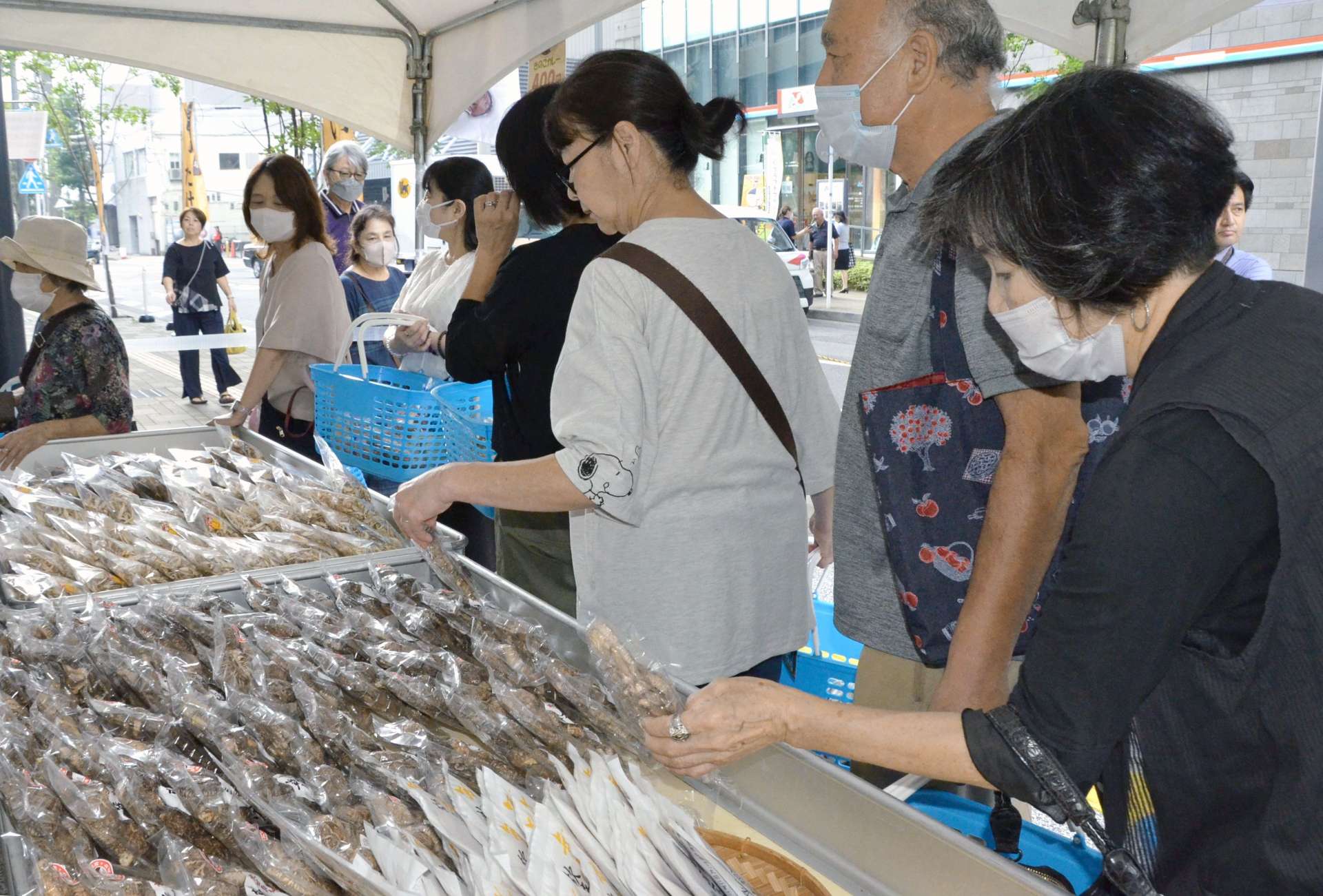 原木シイタケや加工品を品定めする買い物客＝１６日、鹿児島市のよかど鹿児島