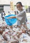 当日収穫された生シイタケを購入する買い物客＝１６日、鹿児島市のよかど鹿児島