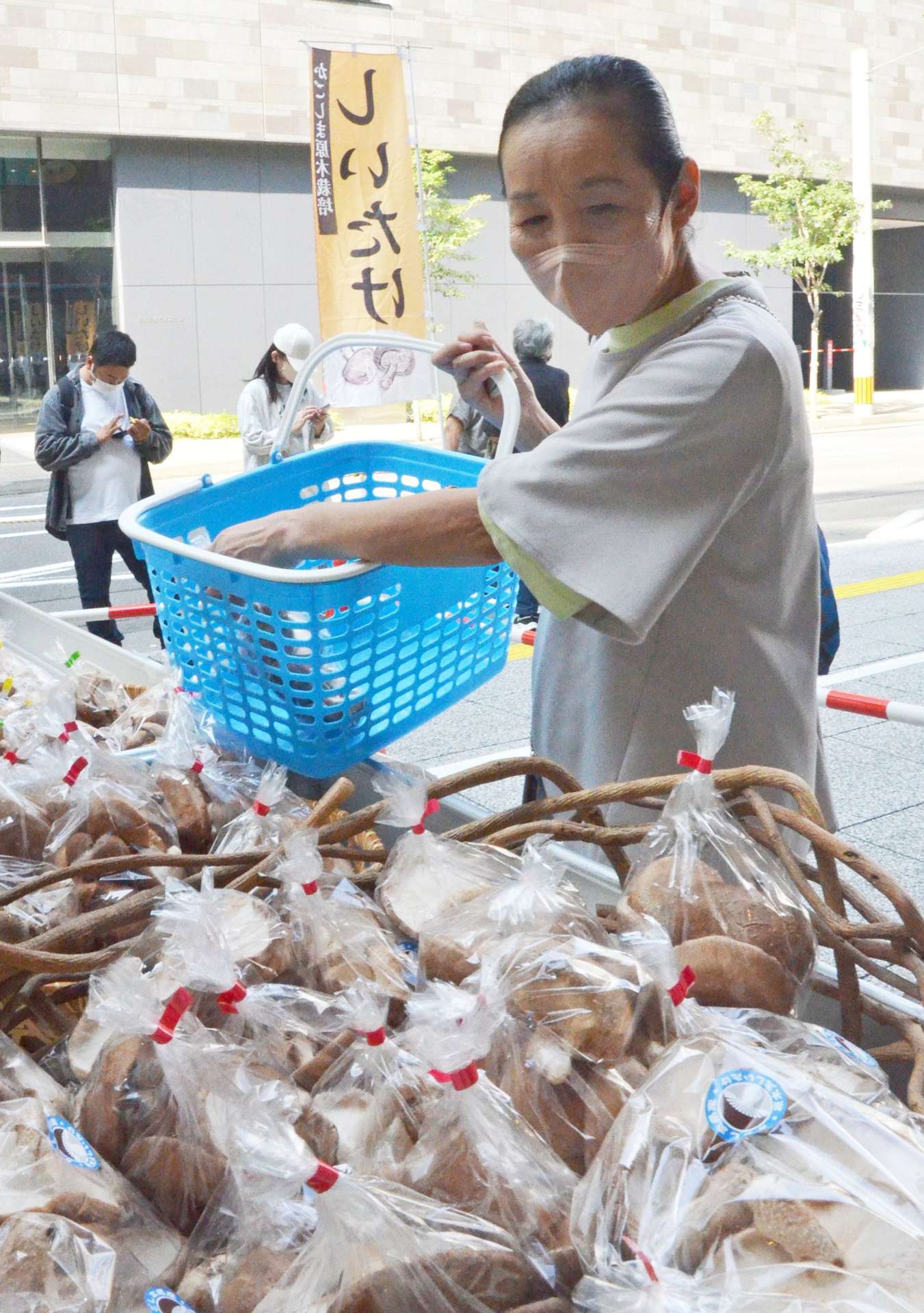 当日収穫された生シイタケを購入する買い物客＝１６日、鹿児島市のよかど鹿児島