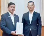 塩田康一知事（左）に新薯かるかんを贈った岩田英明理事長＝１７日、鹿児島県庁