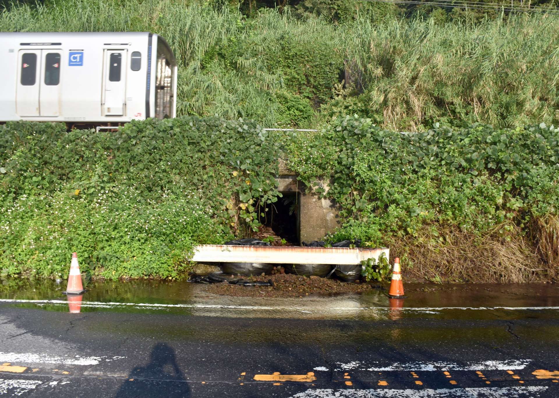 ＪＲ日豊線の線路下を通って水が流れ出している国道１０号＝１５日、姶良市脇元