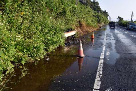 〈別カット〉水が流れ出し、水たまりができている国道１０号＝１５日、姶良市脇元