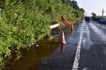 〈別カット〉水が流れ出し、水たまりができている国道１０号＝１５日、姶良市脇元