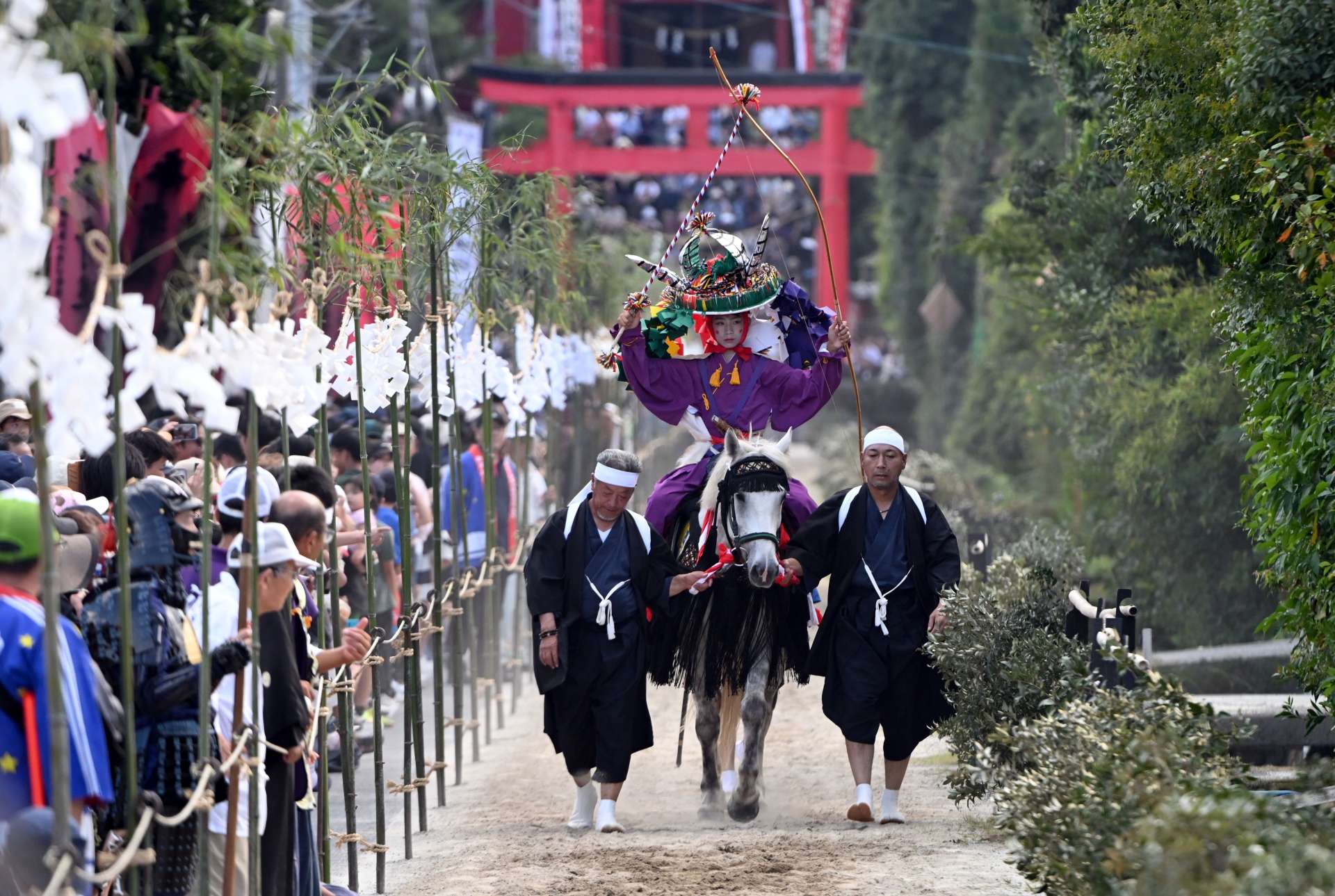 ５８９９出走前、馬場をたどる神馬と射手＝１９日、肝付町の四十九所神社