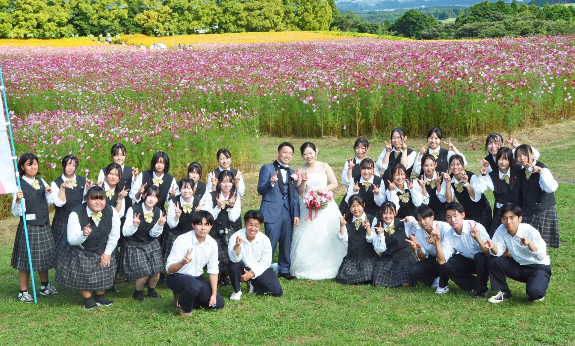 小林秀峰高生と新郎新婦の杉木啓能さんと小堀夏美さん＝小林市南西方の生駒高原