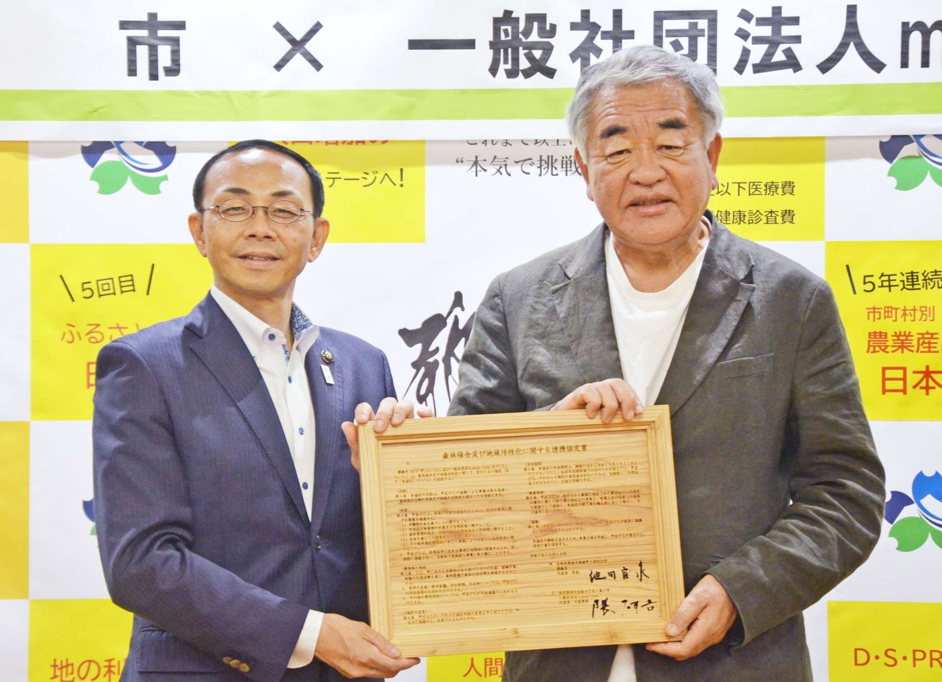 森林保全連携協定を結んだモア・トゥリーズの隈研吾代表（右）と池田宜永市長＝都城市役所