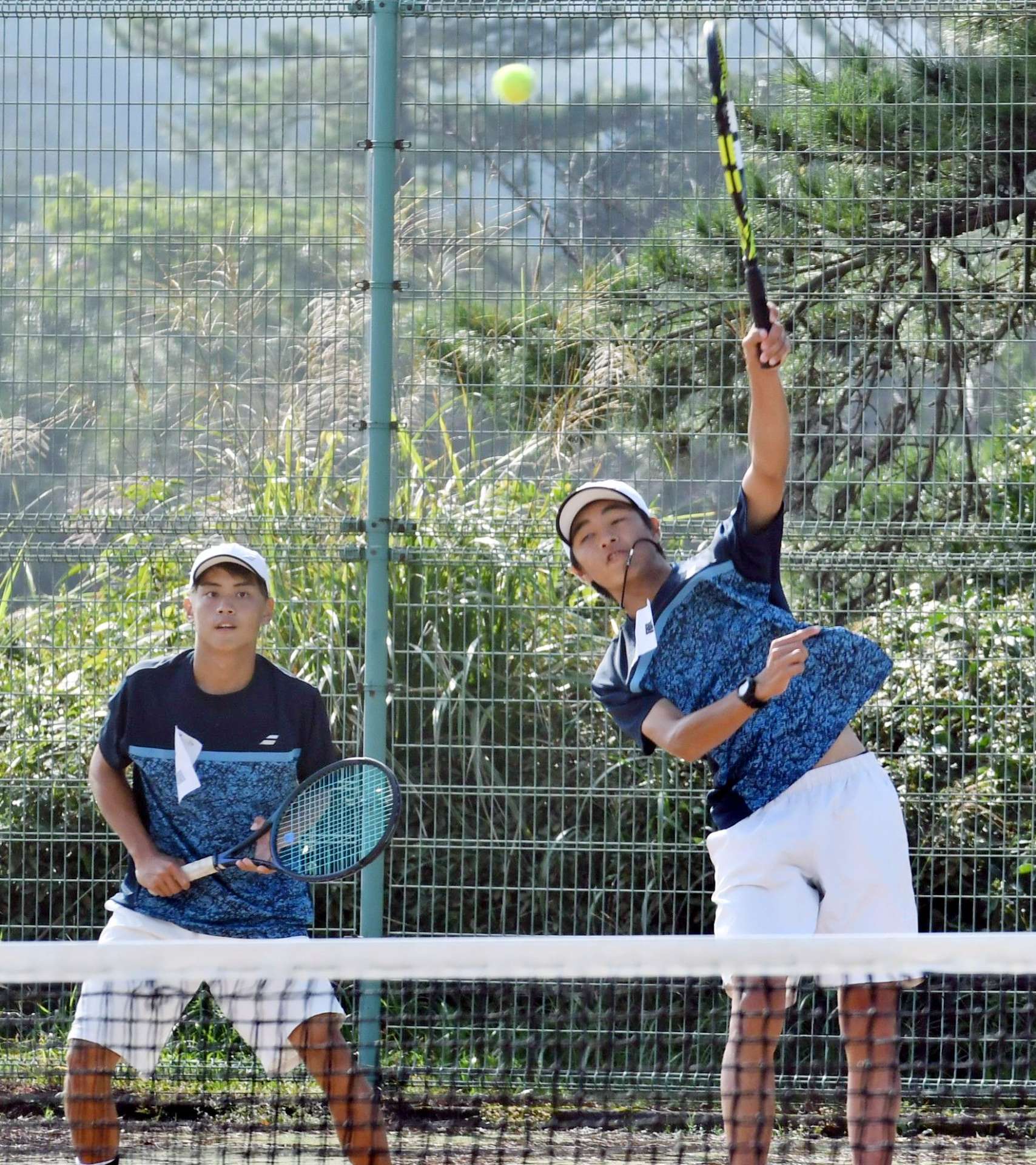 男子団体決勝、息の合ったプレーを見せる鳳凰の浦川（右）・本薗組＝知覧テニスの森公園