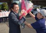 えびの市役所正面玄関前で支持者から花束を受け取る中山義彦市長＝１４日