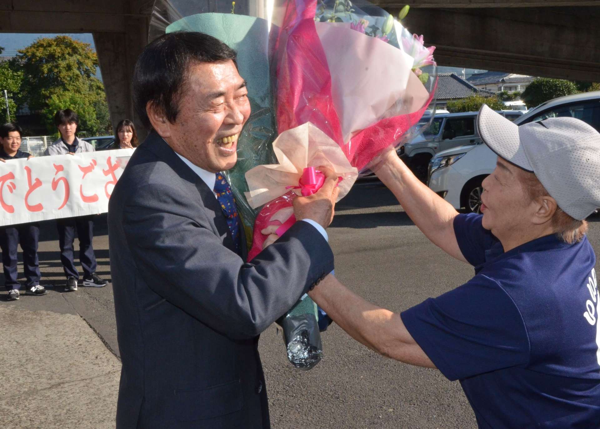 えびの市役所正面玄関前で支持者から花束を受け取る中山義彦市長＝１４日