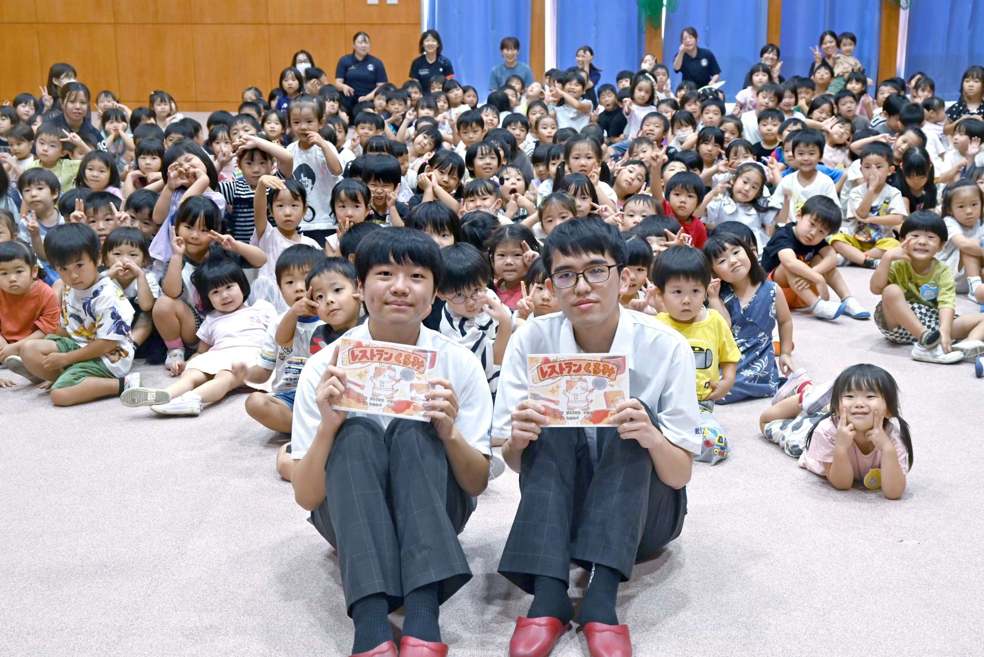 自作の絵本が園児に大人気の地頭方一斗さん（手前左）と渡邉心さん（同右）＝１７日、鹿児島市小松原２丁目のこまつばら幼稚園