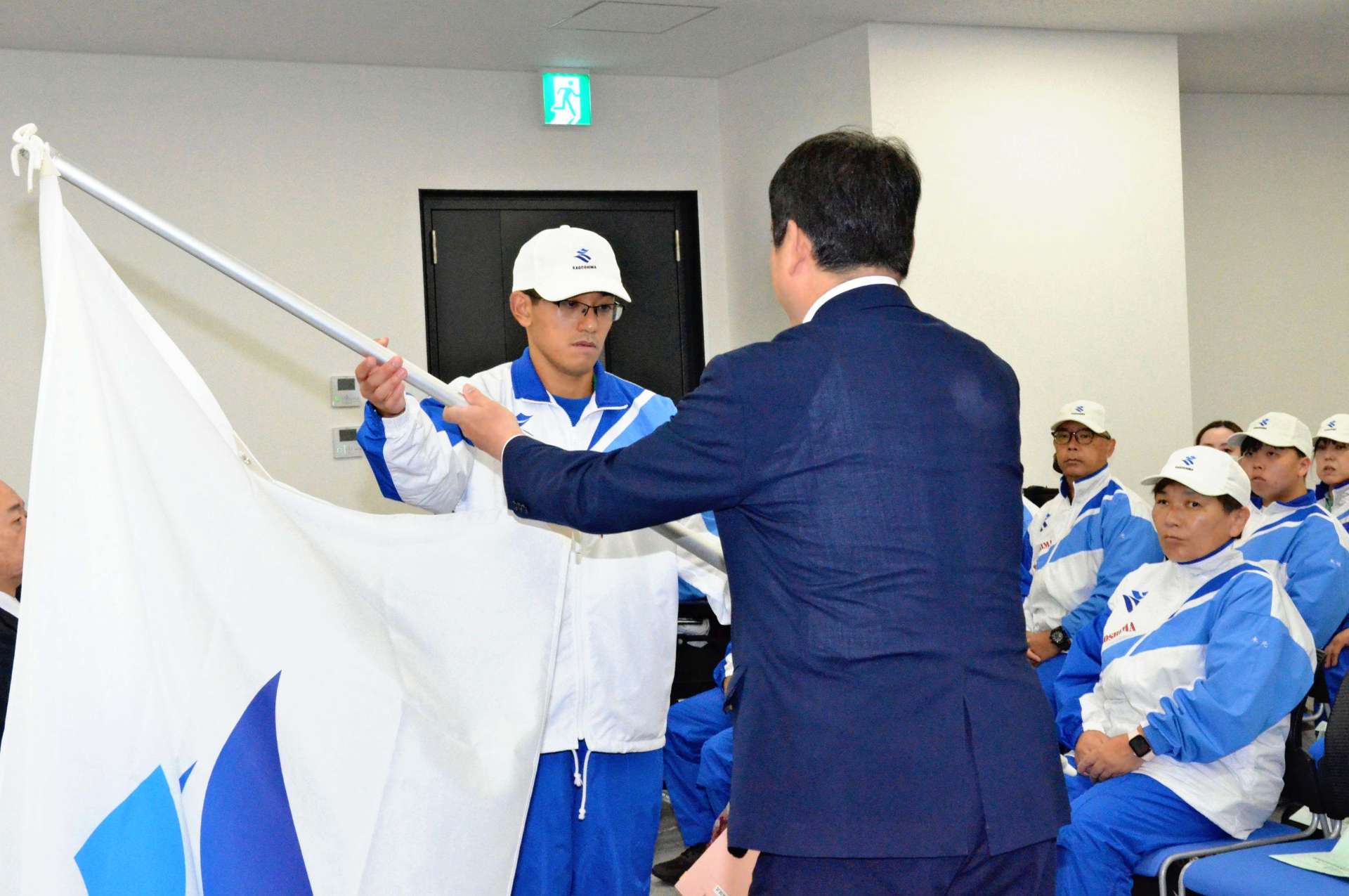 塩田康一知事から県旗を受け取る宮之原誓弥さん＝２３日、鹿児島市のＬｉ－Ｋａ１９２０