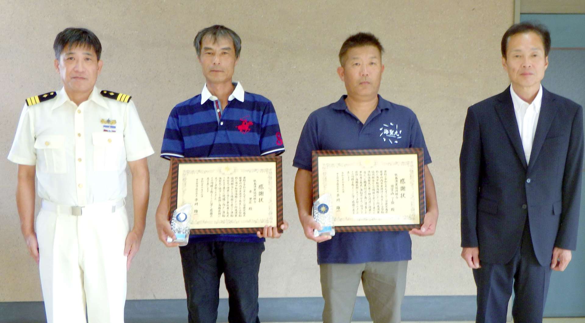感謝状を受け取った日笠山了盛さん（右から２人目）と本里広さん（同３人目）＝薩摩川内市上甑町の市甑島振興局（串木野海上保安部提供）