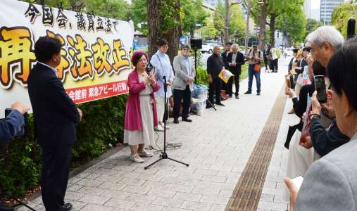 市民団体の街頭行動であいさつする鴨志田祐美弁護士＝１５日、東京都千代田区