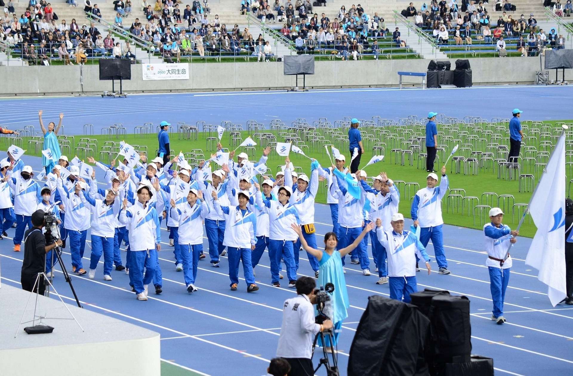 小旗を振り、堂々と行進する鹿児島県選手団＝２５日、滋賀県彦根市の平和堂ＨＡＴＯスタジアム