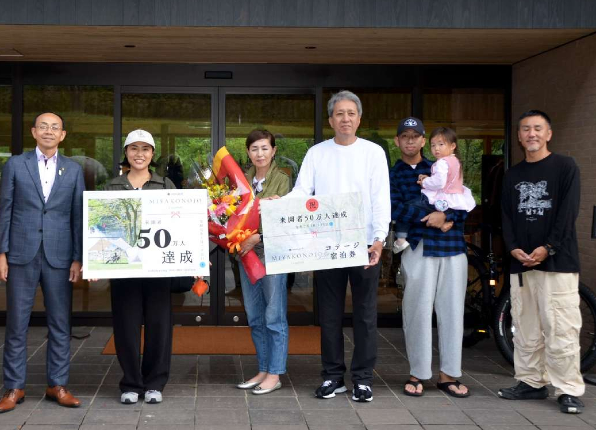 「スノーピーク都城キャンプフィールド」５０万人目の来園者となった松下芳彦さん（右から４人目）ら＝都城市関之尾町