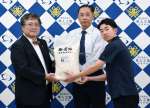 備蓄米を受け取る生徒と保護者＝霧島市隼人町内山田の隼人工業高校