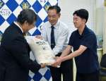 備蓄米を受け取る生徒と保護者＝霧島市隼人町内山田の隼人工業高校