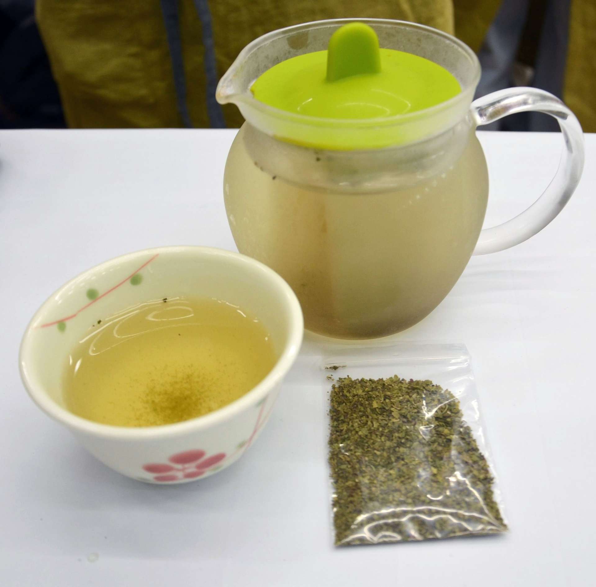 アボカドの茶葉（手前右）と水で抽出した茶。色味は緑茶より黄色がかっている
