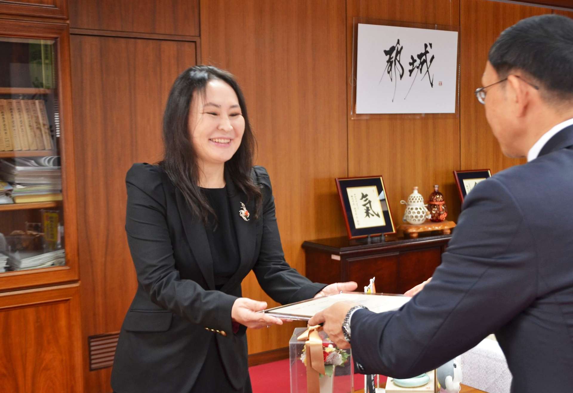 池田宜永市長（右）から立地指定書を交付されるボリヤ・バドジャルガル社長＝２８日、都城市役所