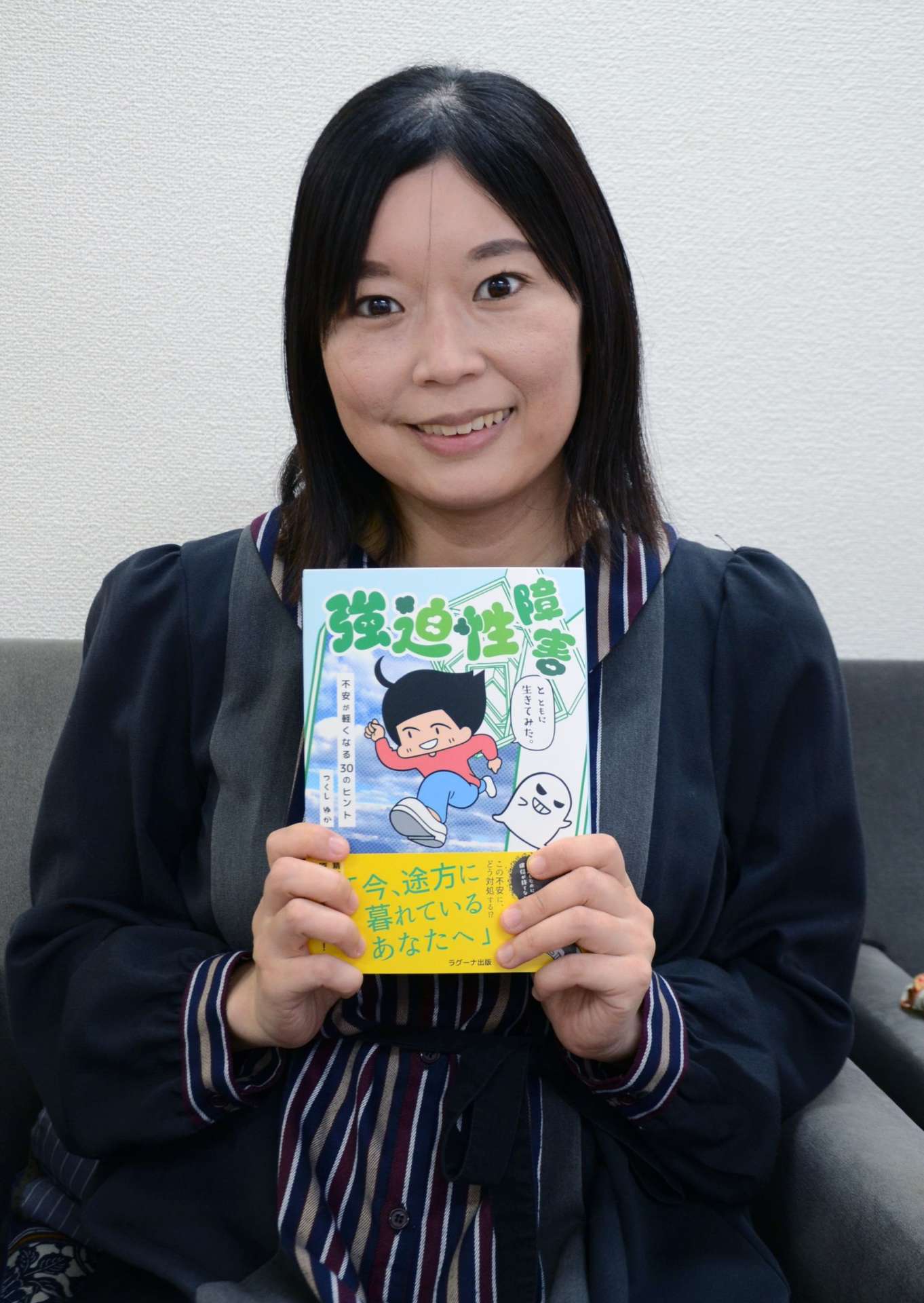 強迫性障害の体験をまとめたエッセー漫画を出版したつくしゆかさん＝１０月２２日、鹿児島市のラグーナ出版