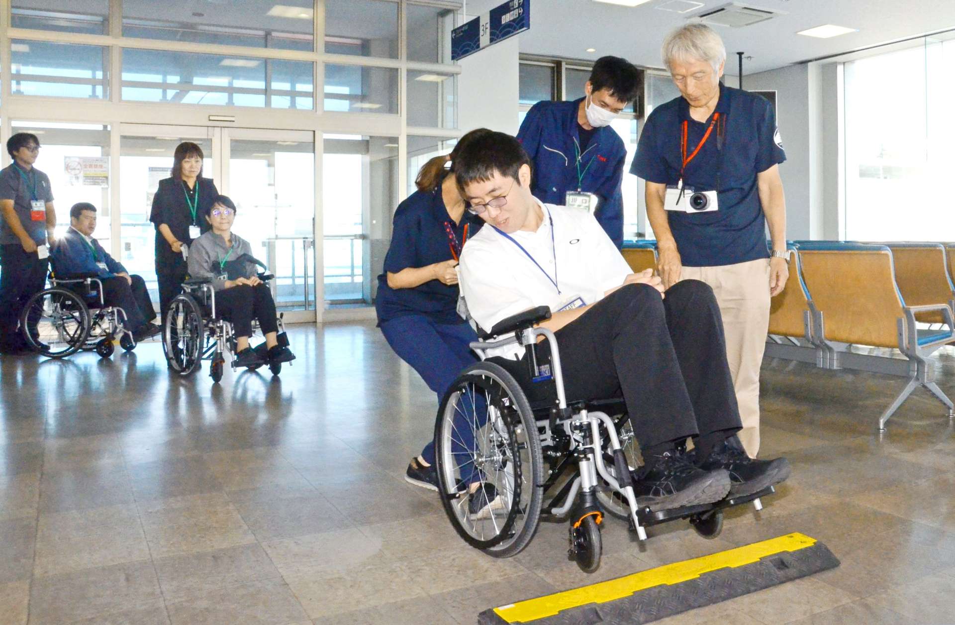 車いす利用者の介助方法を学ぶ参加者＝２９日、鹿児島市の鹿児島新港