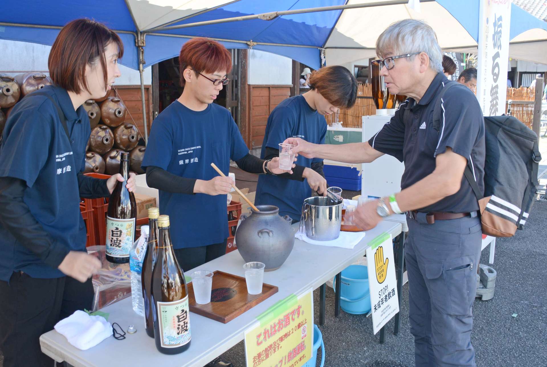 さつま白波の振る舞いを受け取る来場者＝枕崎市の薩摩酒造「明治蔵」