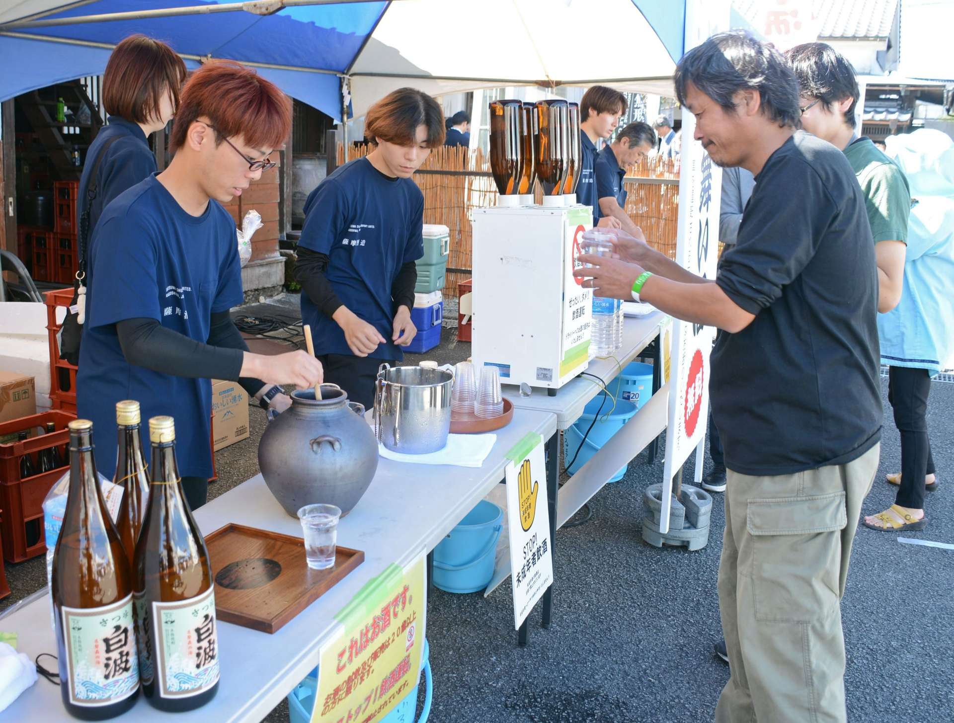 さつま白波の振る舞いを受け取る来場者＝２６日、枕崎市の薩摩酒造「明治蔵」