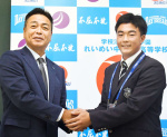 指名あいさつを受け、大久保勝也担当スカウト（左）と握手するれいめい高の伊藤大晟投手＝同校
