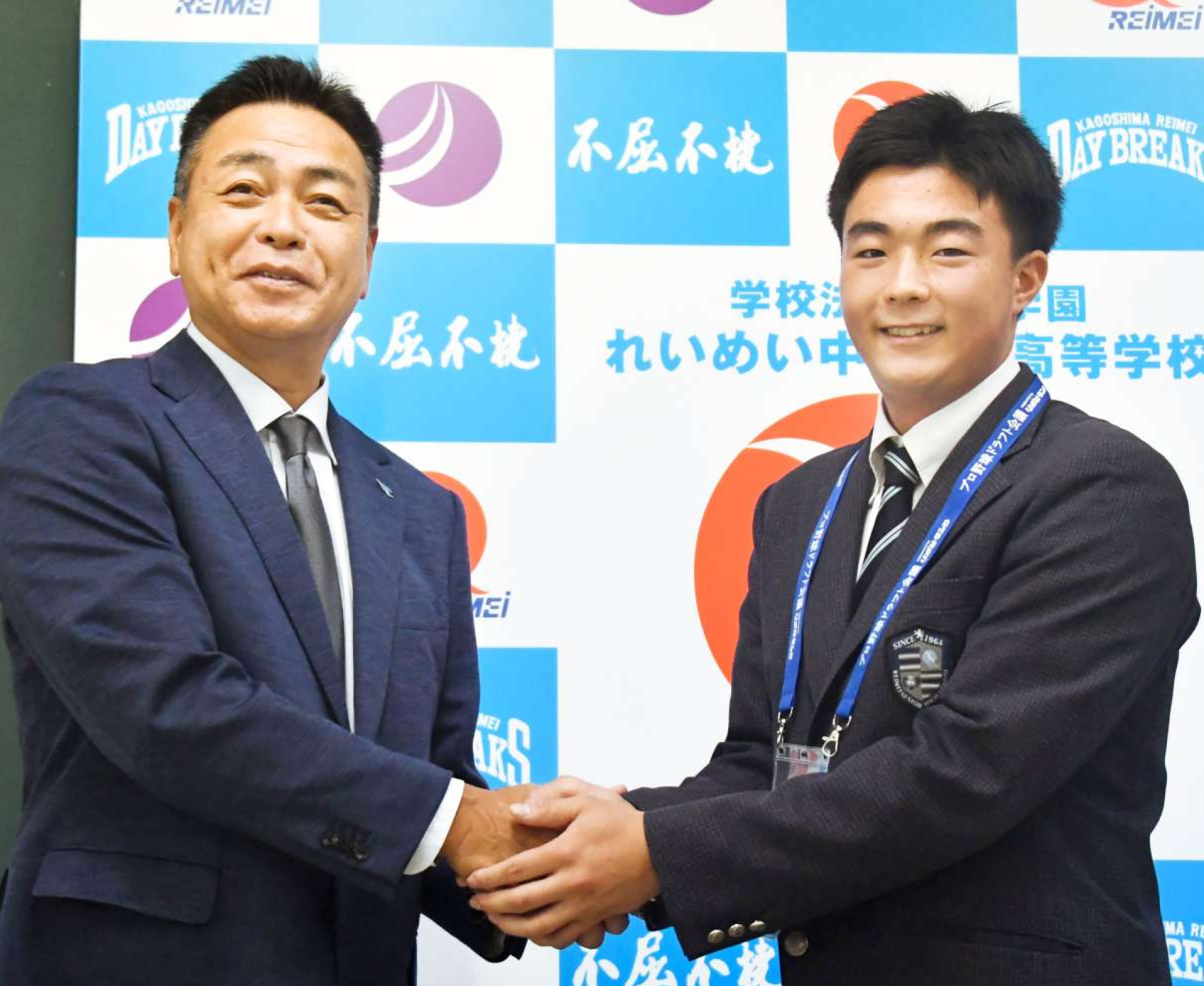 指名あいさつを受け、大久保勝也担当スカウト（左）と握手するれいめい高の伊藤大晟投手＝同校