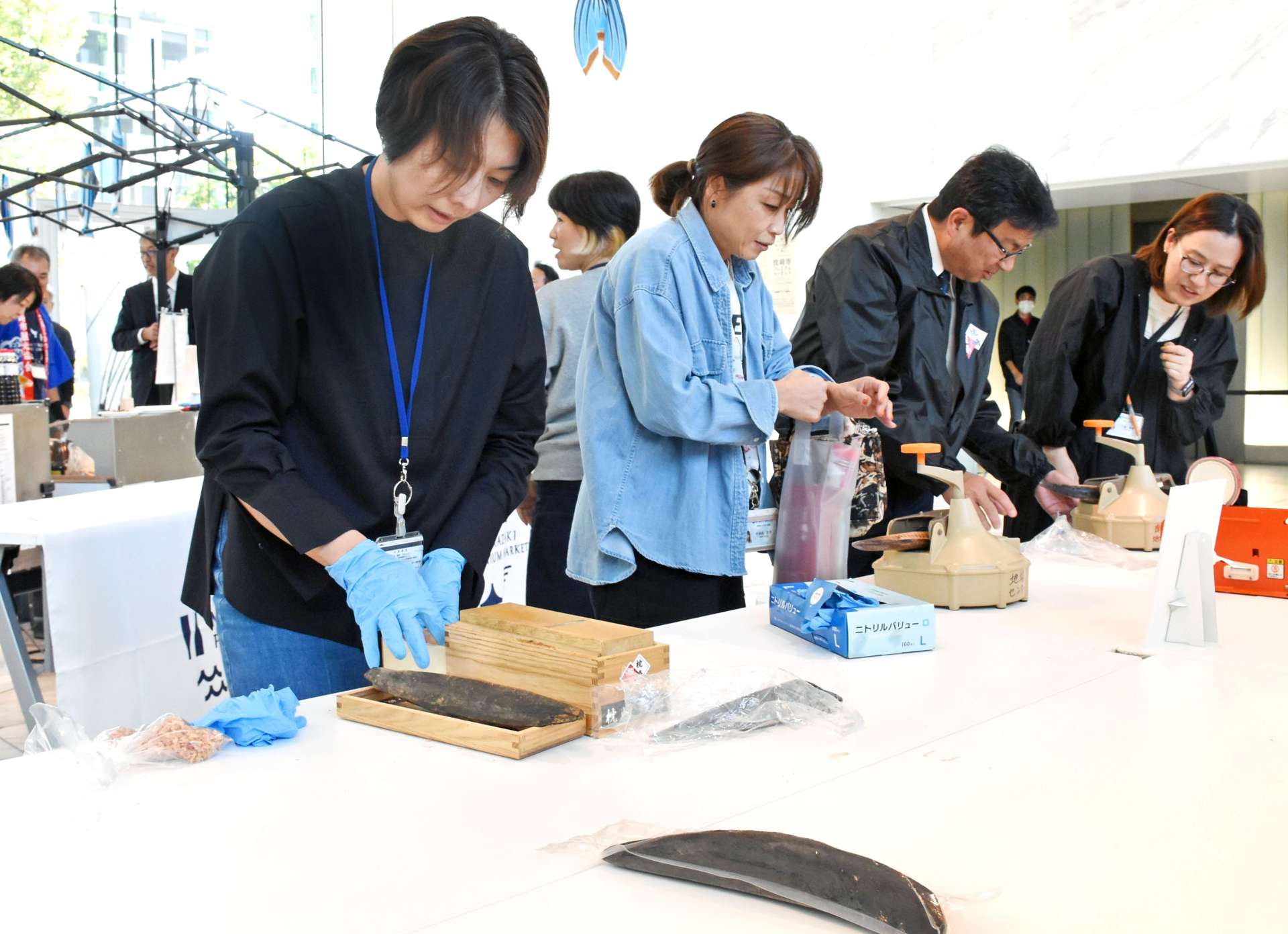 かつお節削りに挑戦する来場者＝３０日、東京・港区北青山