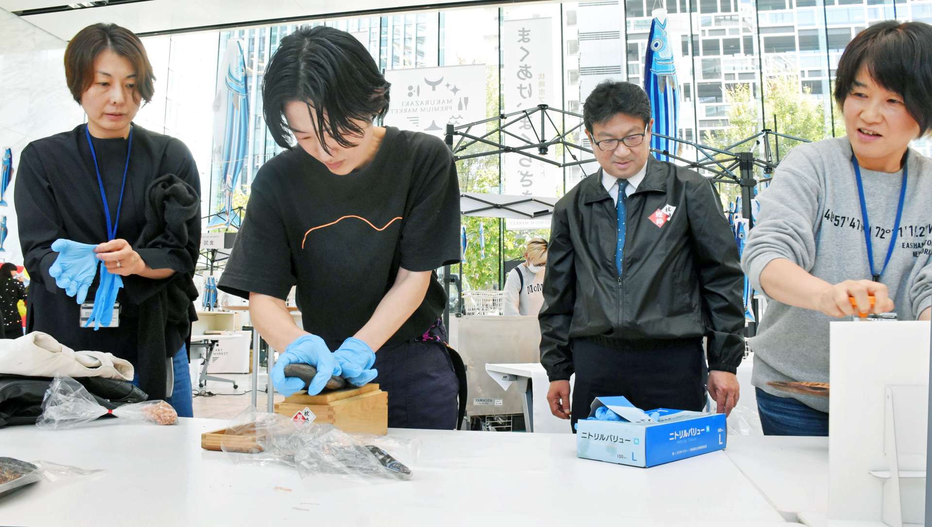 かつお節削りに挑戦する来場者＝３０日、東京・港区北青山