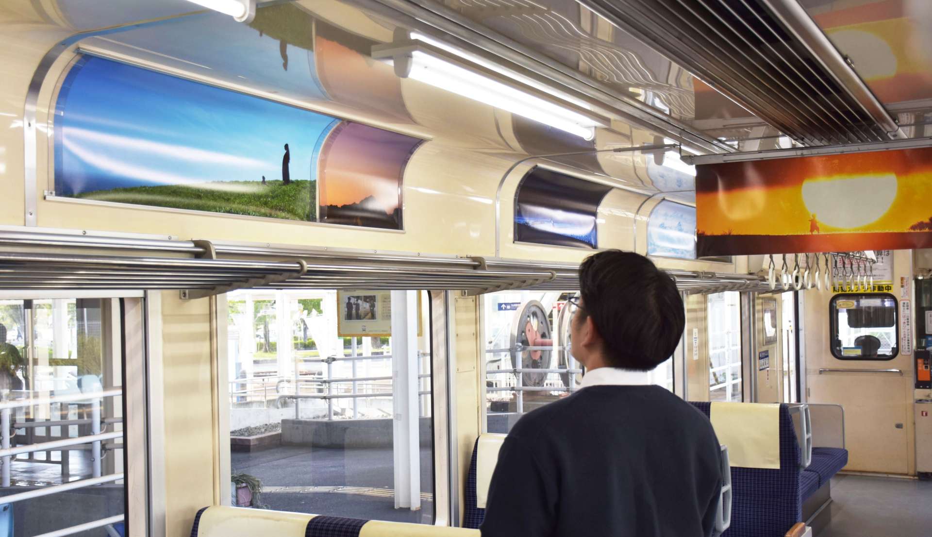 ラッピング車両に展示された齋藤陽道さんの作品＝出水市の肥薩おれんじ鉄道出水駅