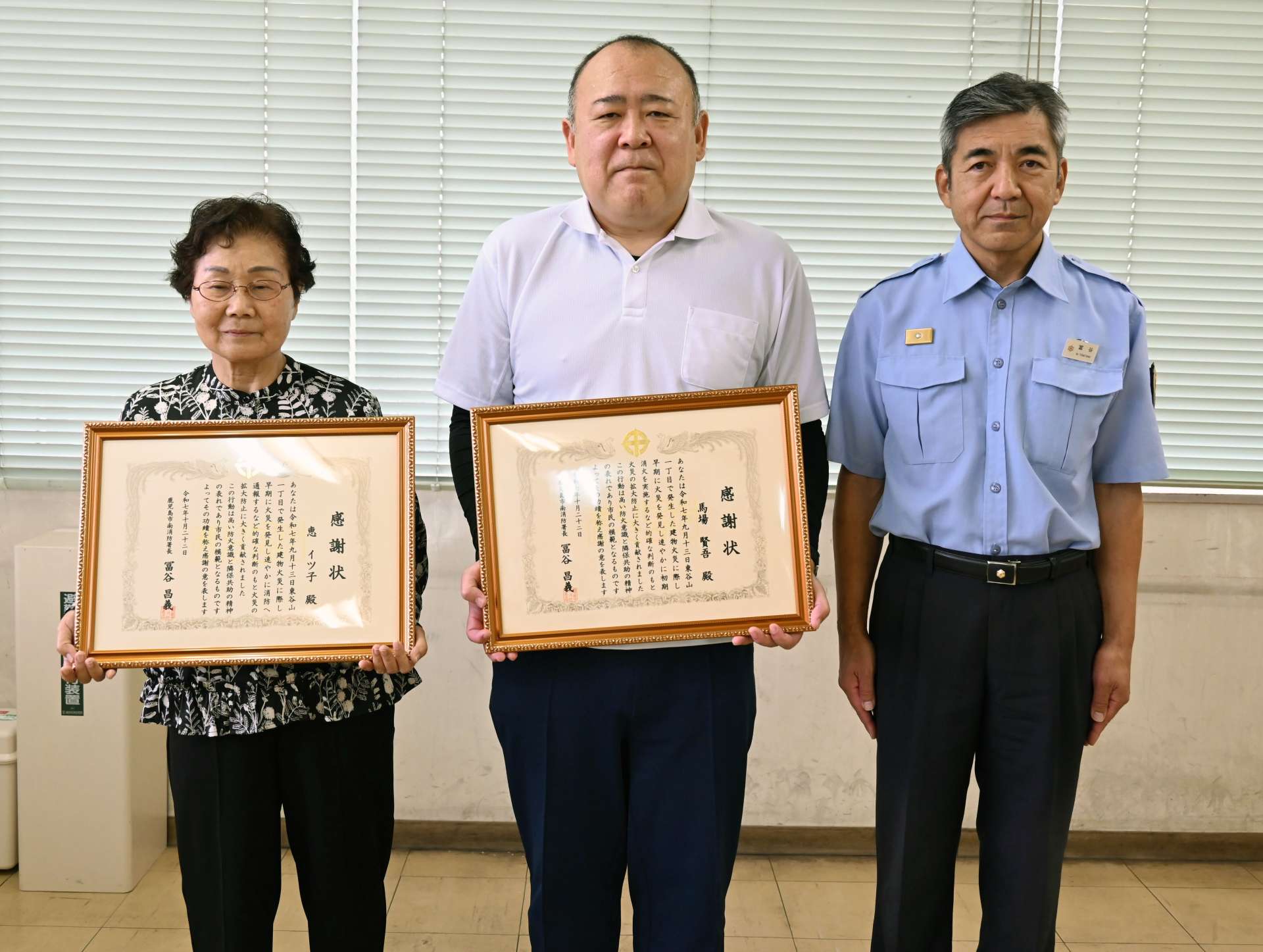 感謝状を受けた馬場賢さん（中央）と恵イツ子さん（左）＝鹿児島市南栄５丁目の南消防署