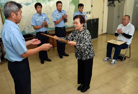 消火協力で感謝状を受ける恵イツ子さん（中央）と馬場賢吾さん（右）＝２２日、鹿児島市南栄５丁目の南消防署