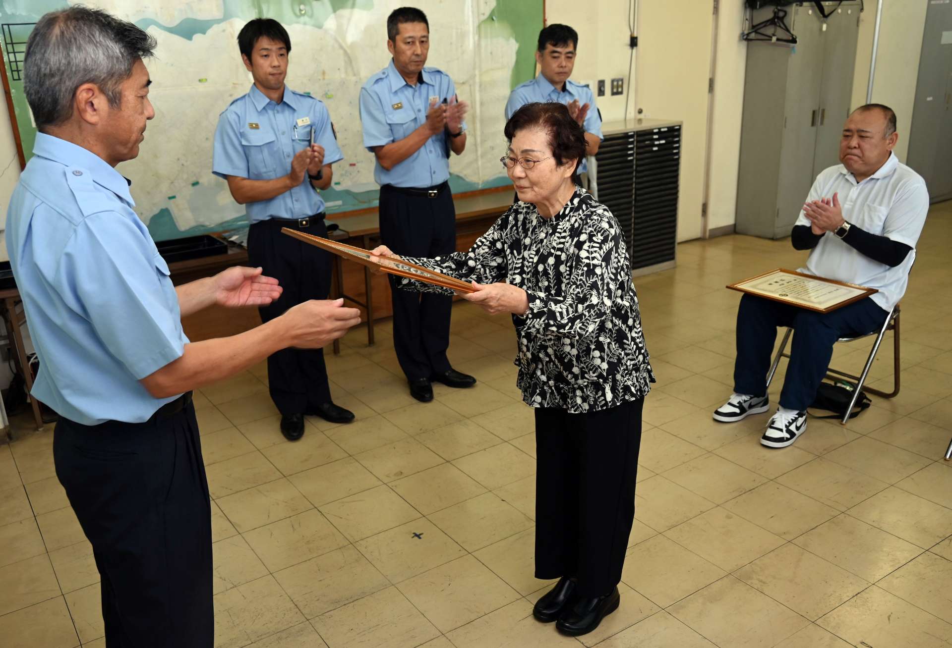 消火協力で感謝状を受ける恵イツ子さん（中央）と馬場賢吾さん（右）＝２２日、鹿児島市南栄５丁目の南消防署