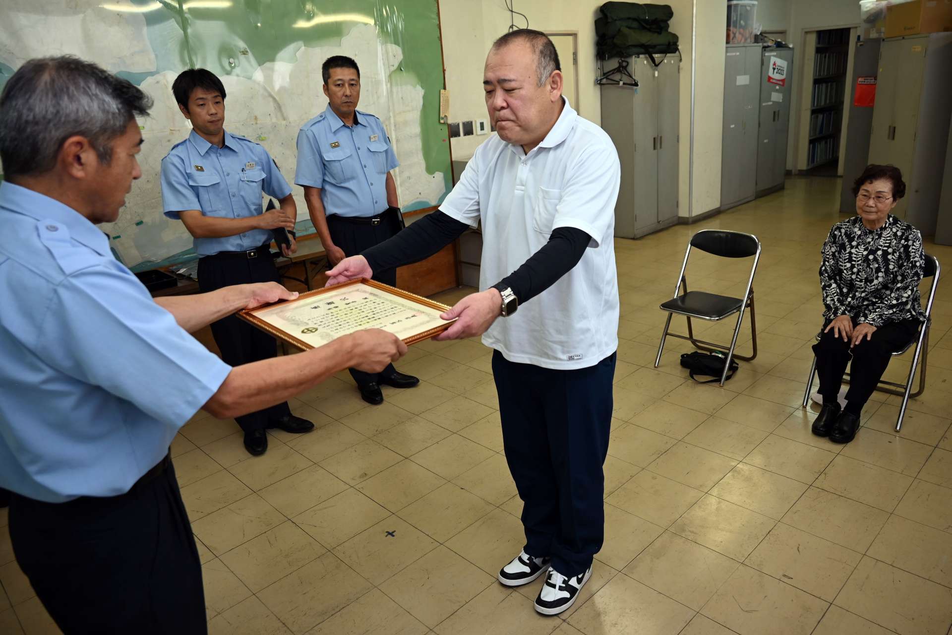消火協力で感謝状を受ける馬場賢吾さん（中央）と恵イツ子さん（右）＝２２日、鹿児島市南栄５丁目の南消防署