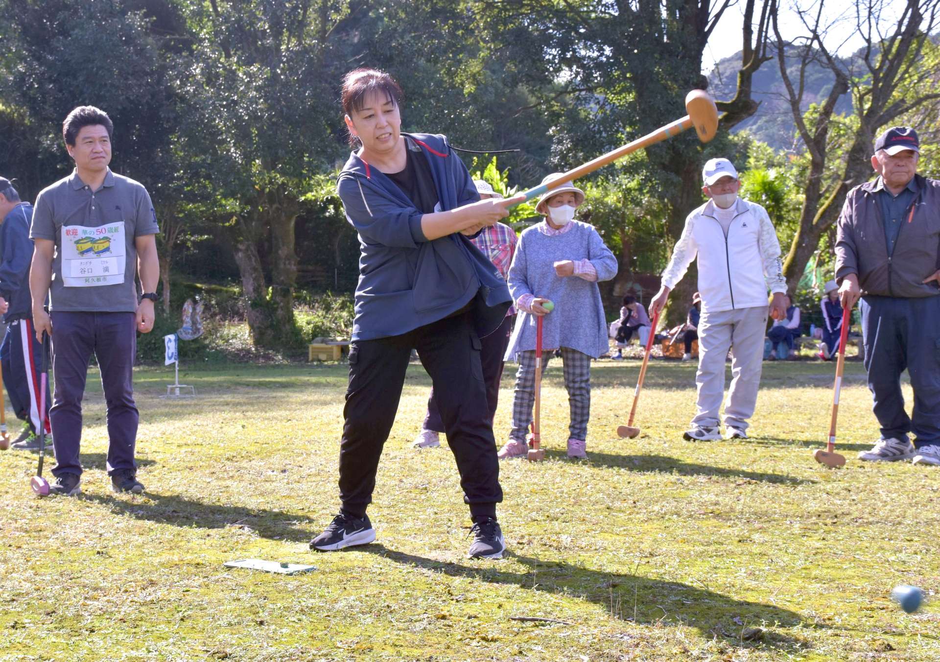 住民たちとグラウンドゴルフを楽しむ５０歳組の谷口満さん（左）と若松紀美代さん（中央）＝【預Ｓ注意】２５日、【預Ｅ注意】阿久根市山下の尾崎小学校