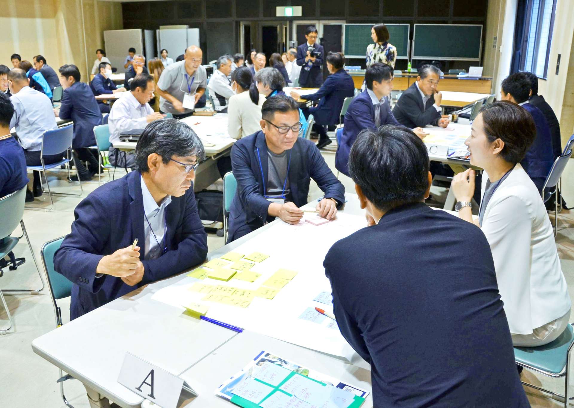 共同体設立の導入セミナーで意見交換する経営者ら＝日置市中央公民館