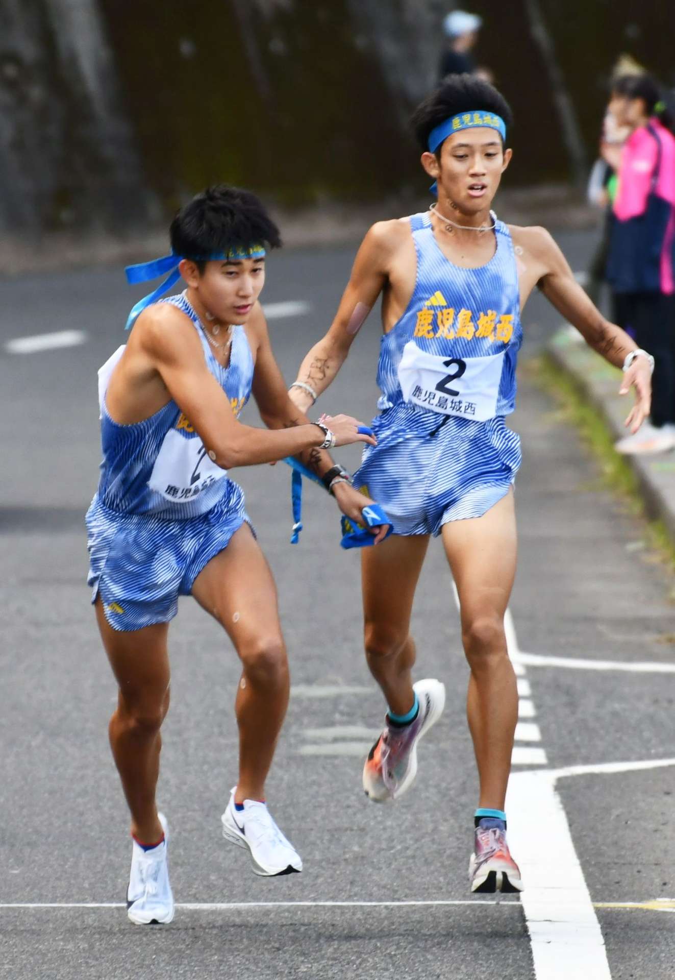 第４中継所、鹿城西・小浦（右）が秋元にたすきをつなぐ＝指宿市