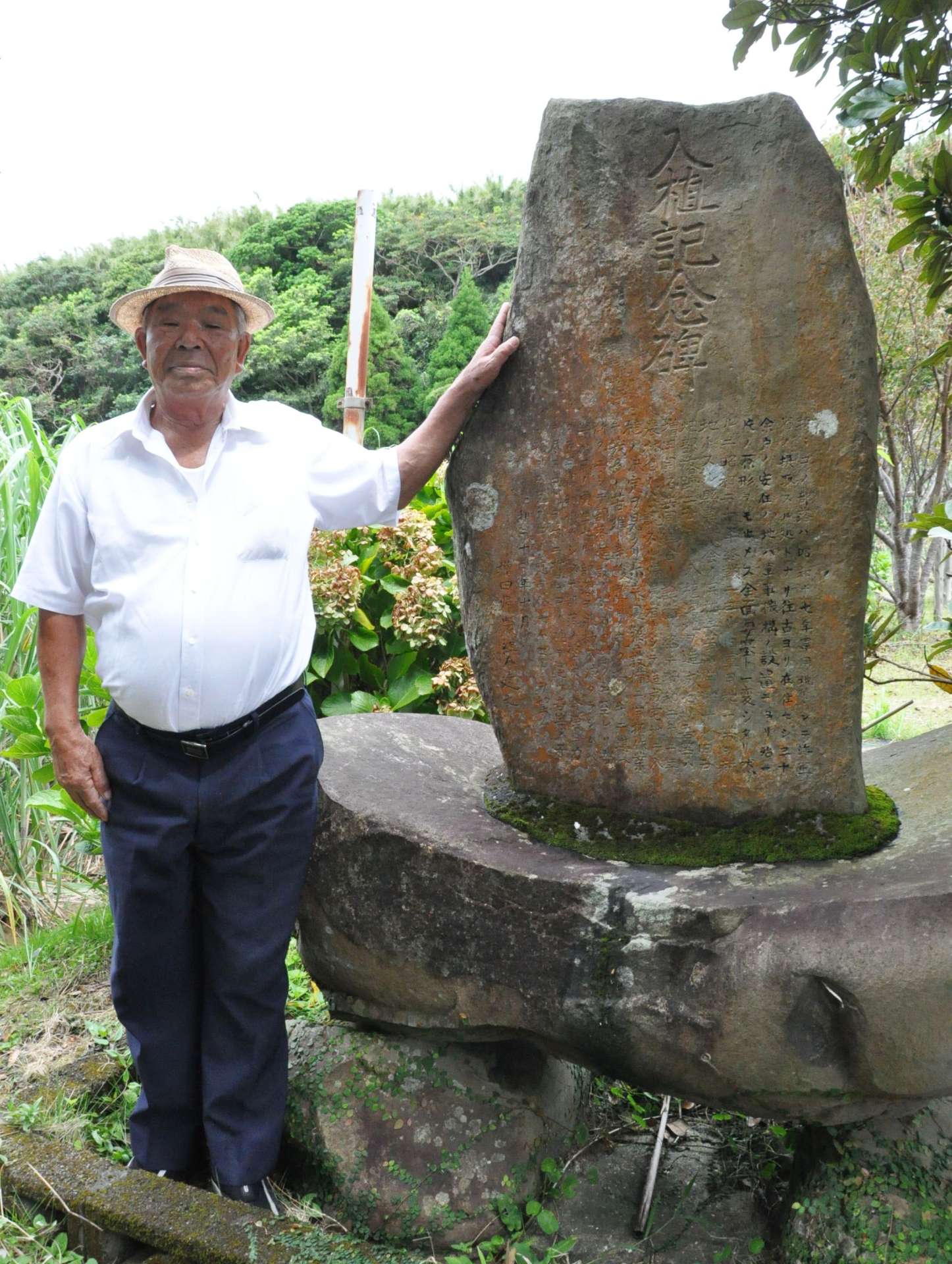 入植記念碑に手を添える宇都岩重さん＝中種子町増田