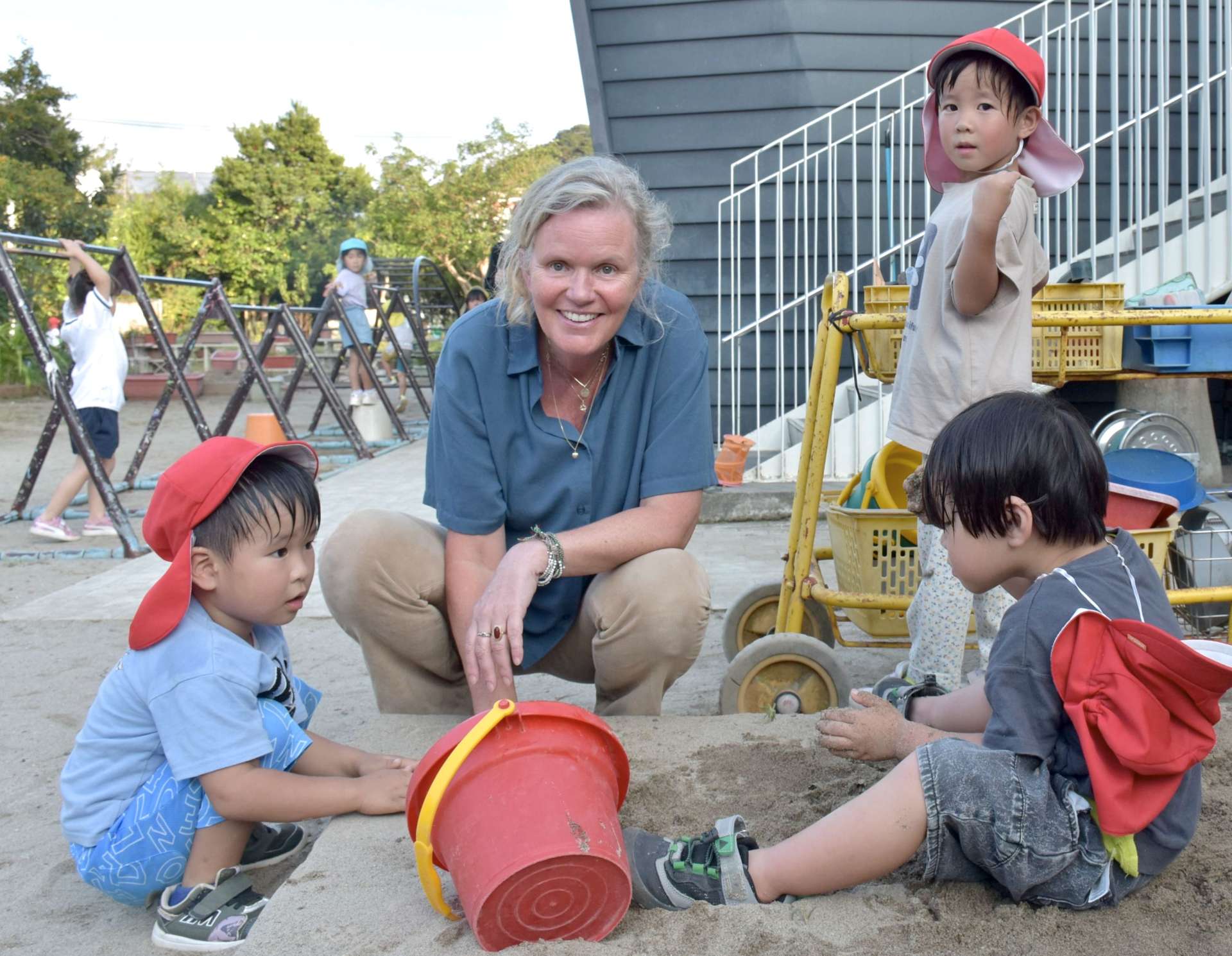 園児に囲まれるペトラ・ヴィーリングさん＝阿久根市のめぐみこども園