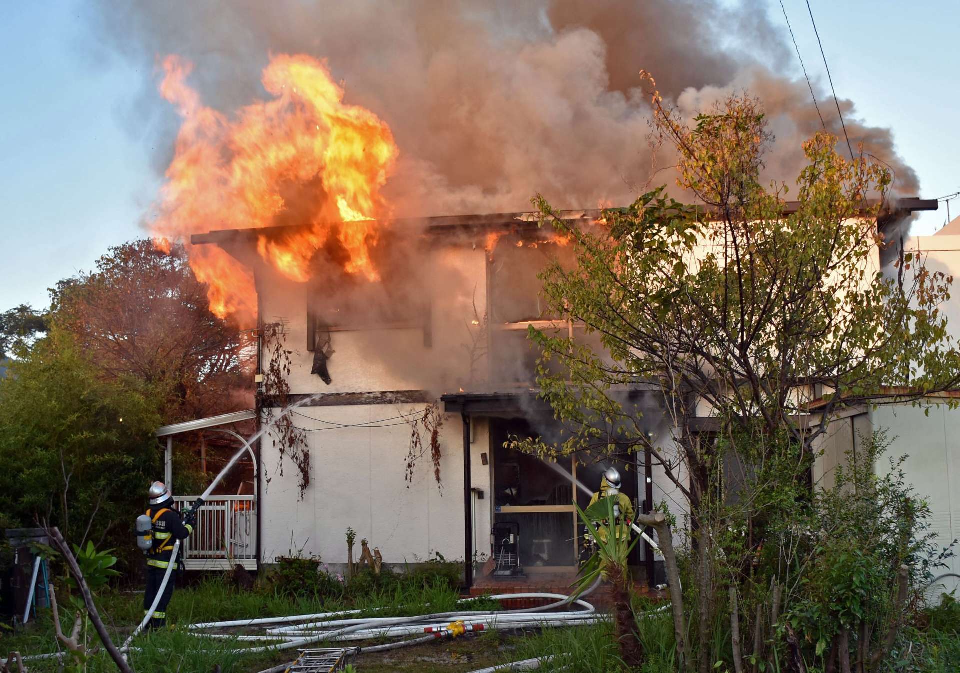 １棟全焼した火災現場で消火活動する消防署員＝３日午前６時５０分ごろ、姶良市西餅田