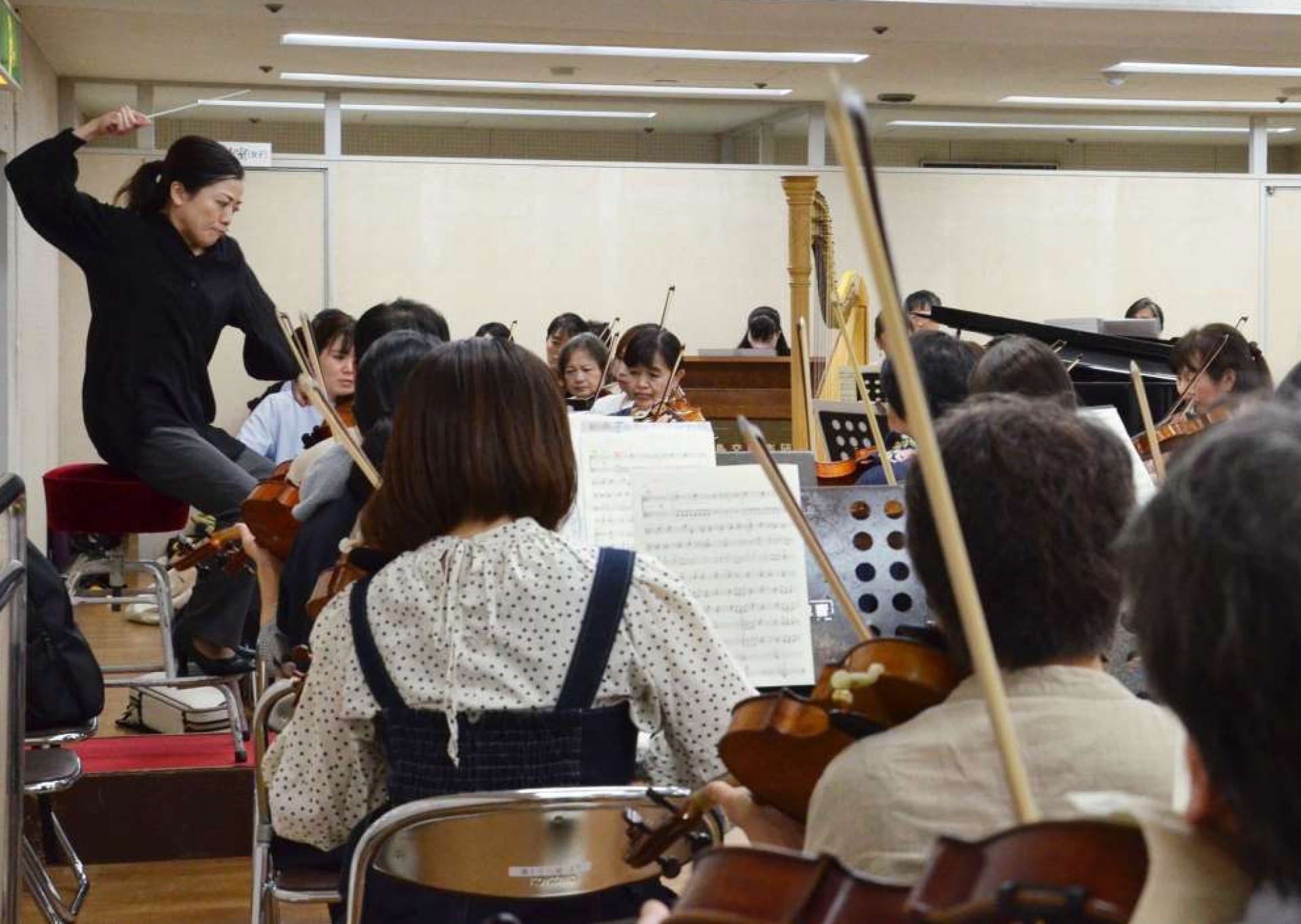 本番を前に熱のこもった練習をする鹿児島交響楽団と指揮者の三ツ橋敬子（左端）＝１０月下旬、鹿児島市の宝山ホール