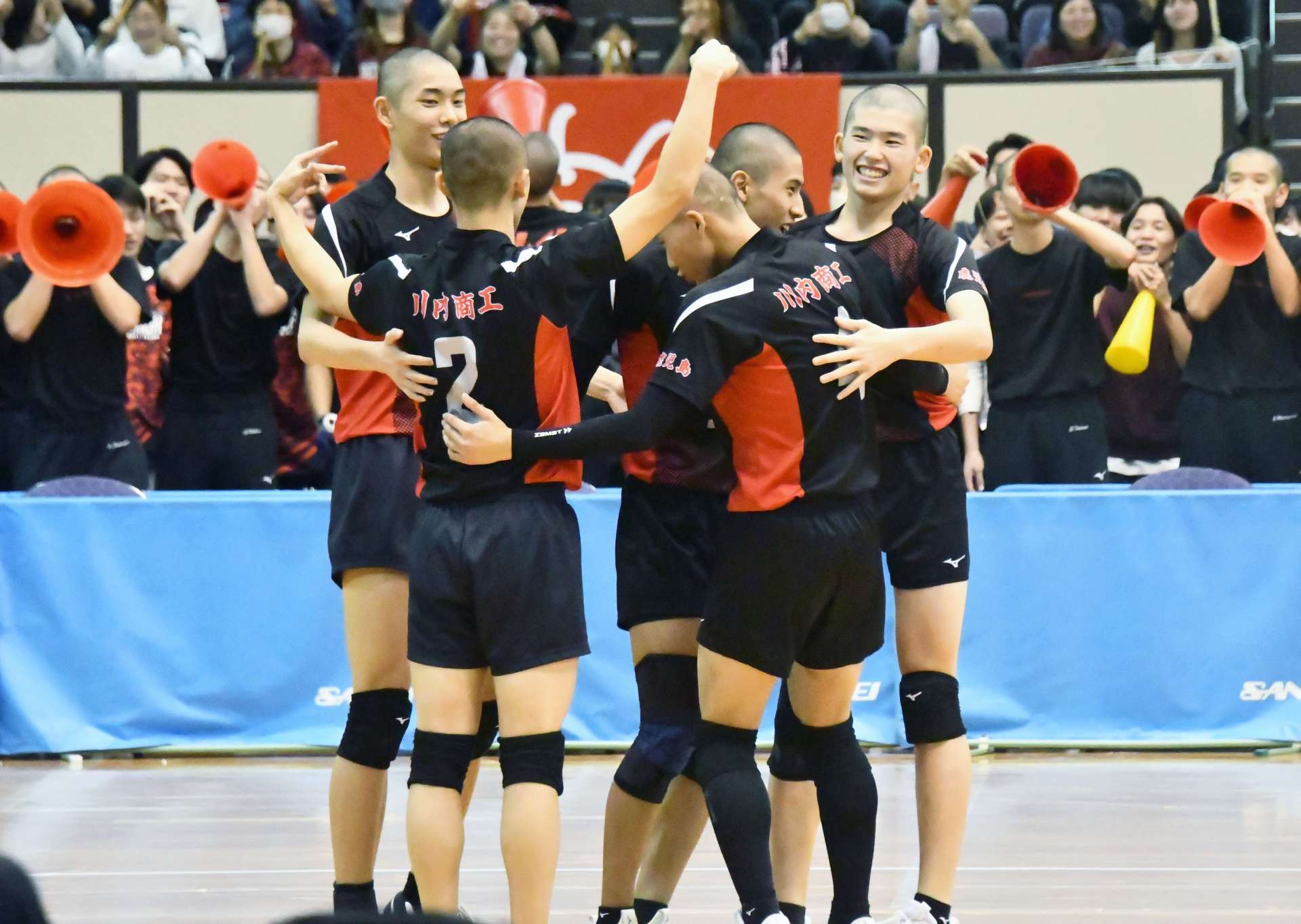 第１セット、得点が決まり喜ぶ川内商工の選手たち＝鹿児島市の西原商会アリーナ